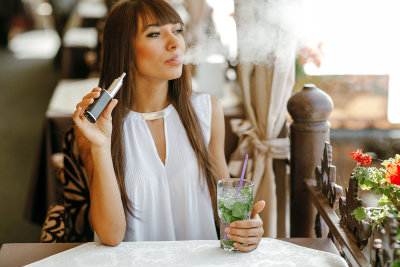Woman Vaping In A Cafe