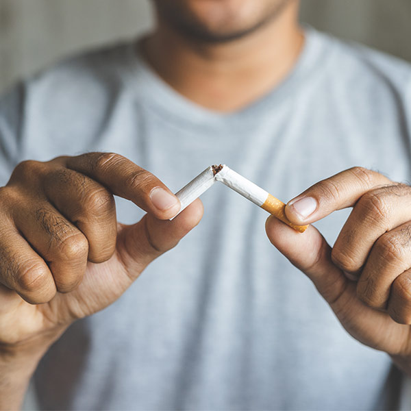 Man breaking cigarette in half