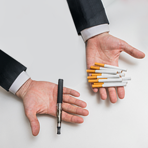 Man Holding Vape and Cigarettes in His Hands