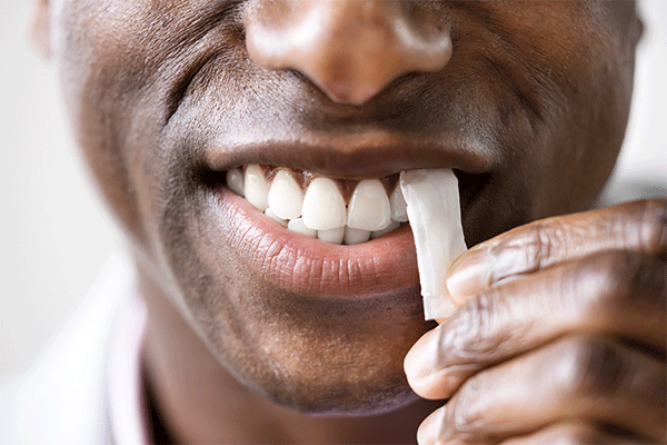Man Placing Nicotine Pouch Between the Lip and Gum