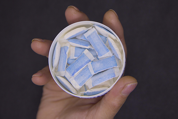 Person Holding Tin Containing Nicotine Pouches