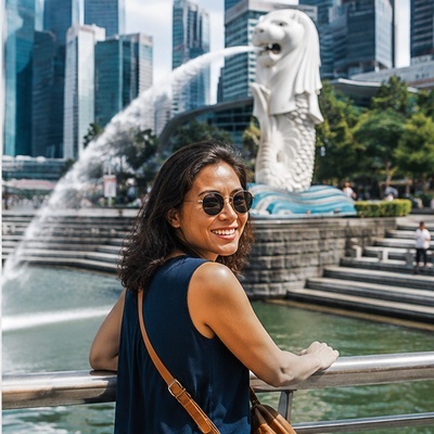 Traveller enjoying the Merlion and Marina Bay skyline in Singapore, a destination with strict restrictions on vaping.