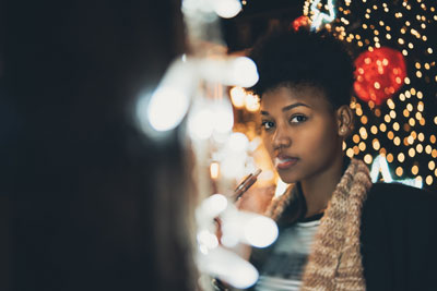 Woman vaping next to Christmas tree