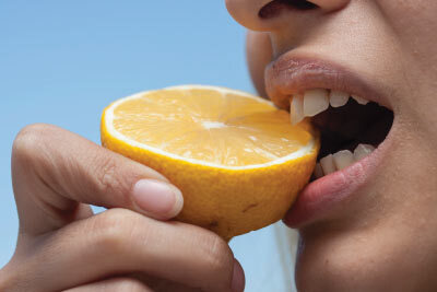 Woman Sucking Lemon to Cleanse Palate