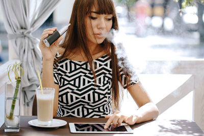 Woman Vaping In A Caffee