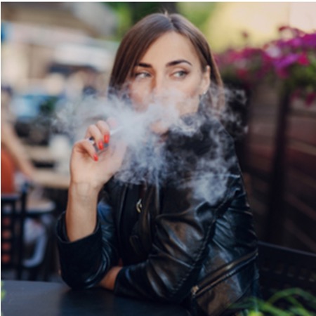 woman vaping in a garden