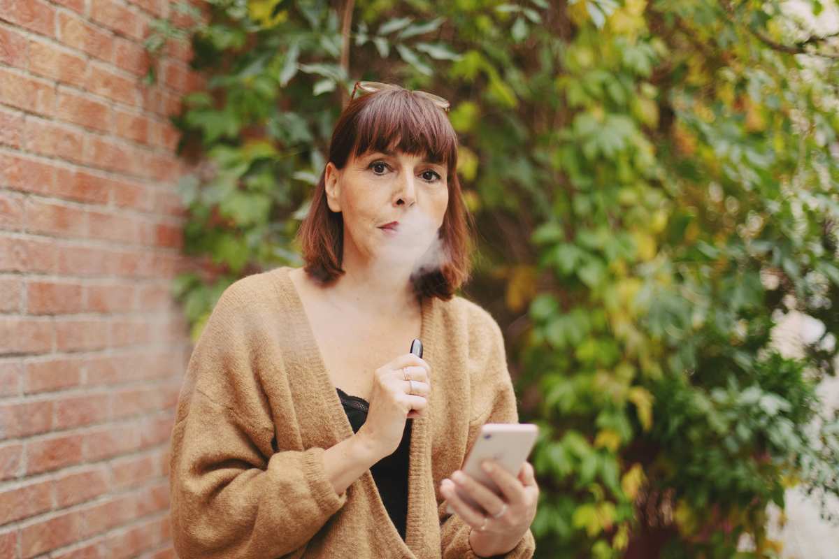 Adult vaper using a refillable pod kit outdoors - the format most UK vapers switched to after the disposable ban