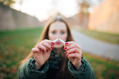 Woman who quit smoking breaks cigarette in half