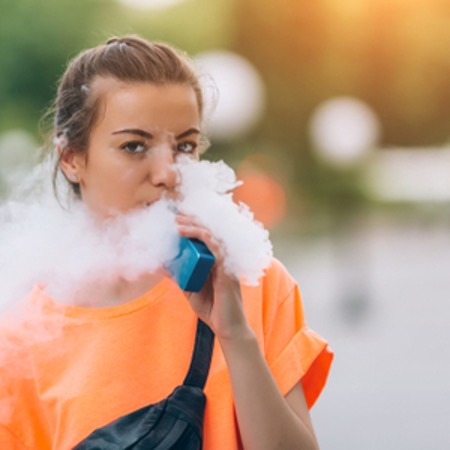Young Woman Vaping in the Street